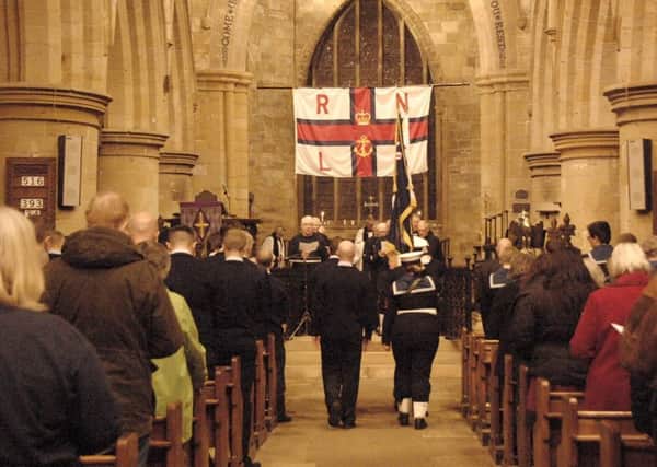 The standard bearers walking down the aisle at the beginning of the service.