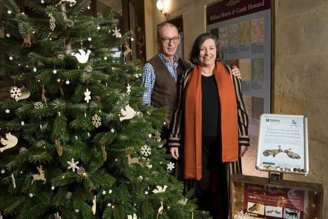 Mr and Mrs Howard stand next to the charity Christmas tree. Photograph taken by Andy Bulmer.