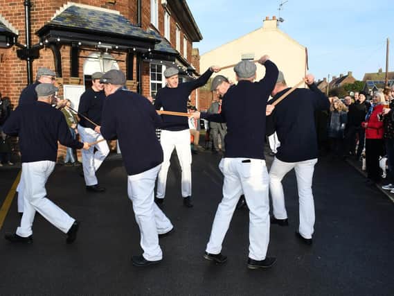 The dancers wear navy ganseys, white trousers and caps for their performances around the village.