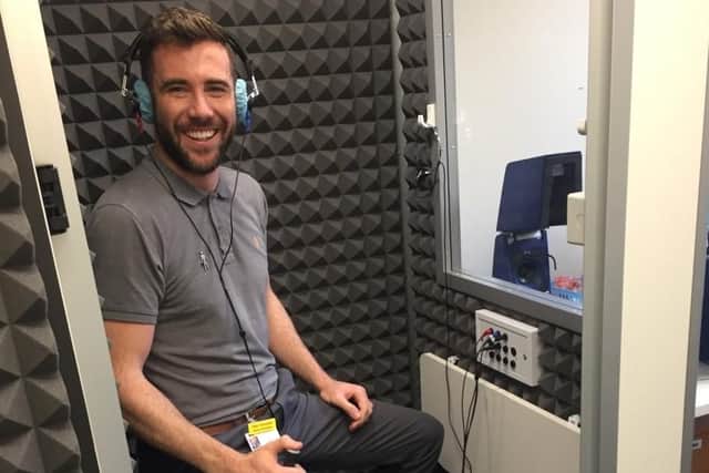 Senior audiologist Alex Trousdale demonstrates the new soundproof booth