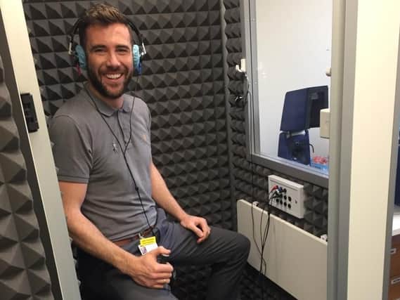 Senior audiologist Alex Trousdale demonstrates the new soundproof booth