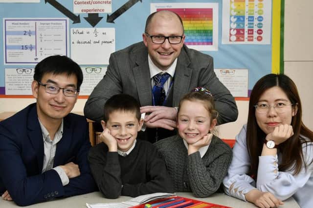 Teachers Lu Yong and Chen Jiajun do some class work with pupils Noah Simpson and Ruth Davis. Also pictured, teacher Matthew Davies who liaised with the visiting teachers.