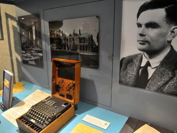 Alan Turing's photograph, alongside an Enigma decoding machine in the museum at GCHQ at Scarborough.