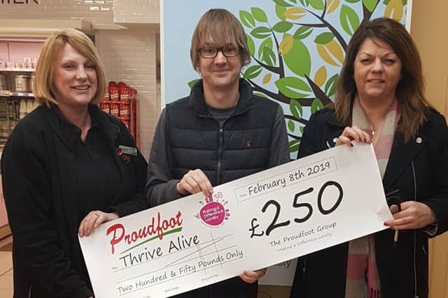 Tim Harvey (centre) receives the cheque from Proudfoot and Nisa.