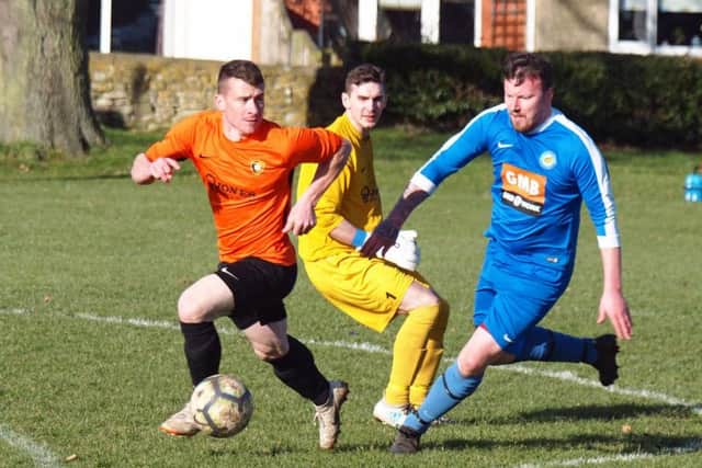 Edgehill defender Ricky Nock looks to keep the ball away from Ayton striker Ian Laing