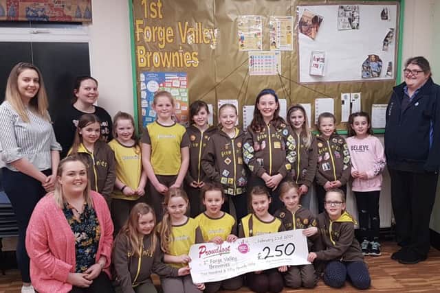 The 1st Forge Valley Brownies are presented with a cheque from Proudfoot supermarkets.