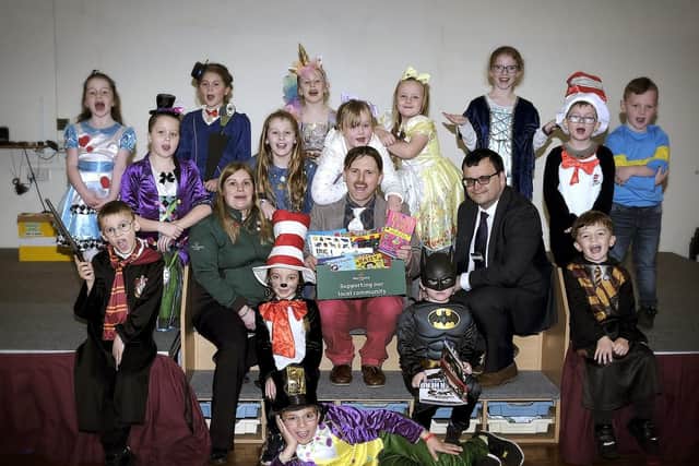 Morrisons staff Ellie Waite and Paul Cole present School Head Richard Crabtree with some brand new books.