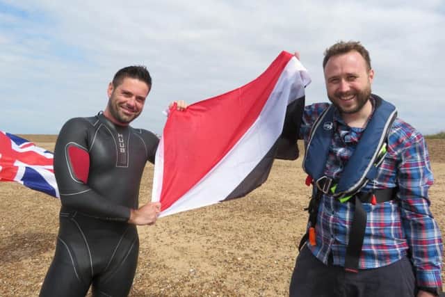 Rob Barker of Barksy Media and Richard Royal holding the Sealand flag on Felixstowe beach after the swim.