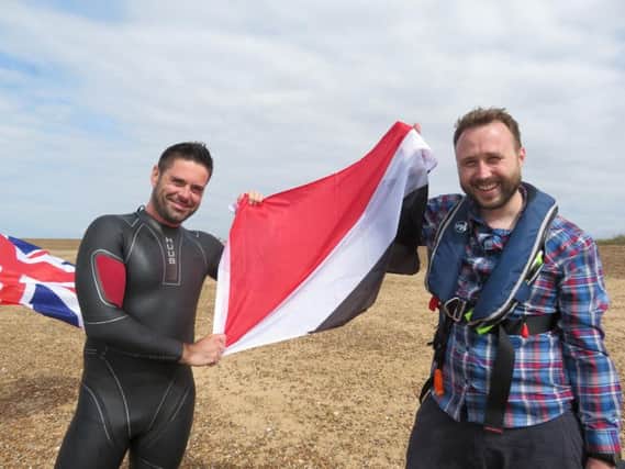 Rob Barker of Barksy Media and Richard Royal holding the Sealand flag on Felixstowe beach after the swim.