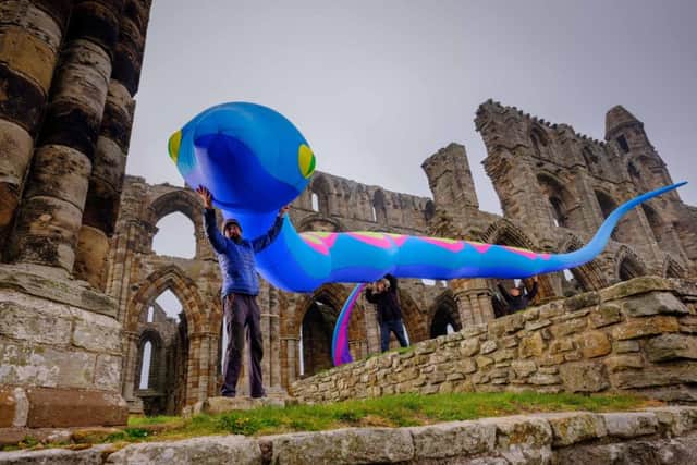 English Heritage staff secure a temporary installation of giant inflatable snakes at Whitby Abbey.