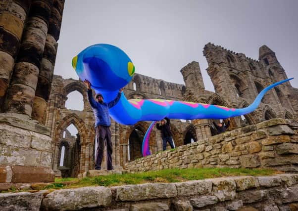 English Heritage staff secure a temporary installation of giant inflatable snakes at Whitby Abbey.