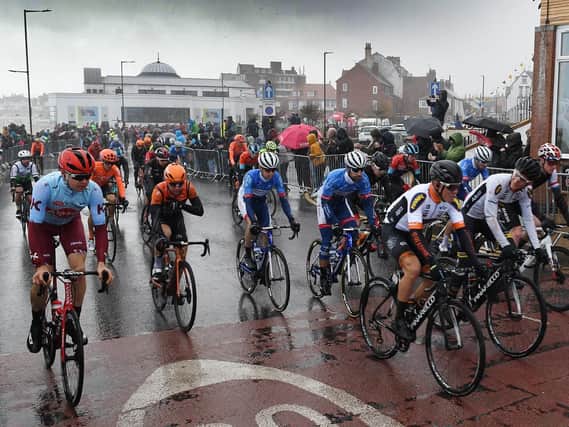 Rain lashes the riders on the start line, as stage three gets underway.