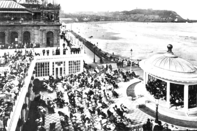 Picture shows Scarborough Spa and South Bay looking towards the Castle Headland. In the foreground crowds of people are watching a performance in the bandstand. The picutre was taken long before the development of the Sun Court enclosure at the Spa.