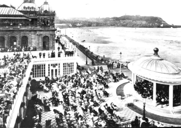 Picture shows Scarborough Spa and South Bay looking towards the Castle Headland. In the foreground crowds of people are watching a performance in the bandstand. The picutre was taken long before the development of the Sun Court enclosure at the Spa.