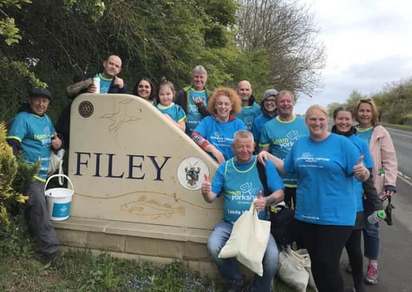 Chris Hewitt and his supporters pose for a picture at the Filey sign as they finish the 86-mile walk.