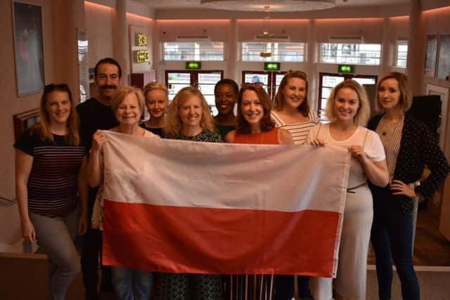 The cast of the play flying the Polish flag