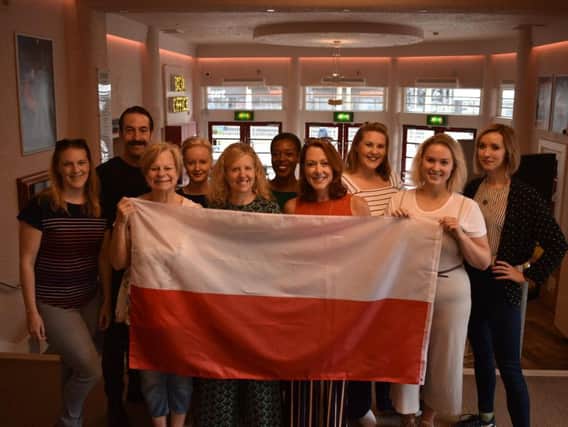 The cast of the play flying the Polish flag