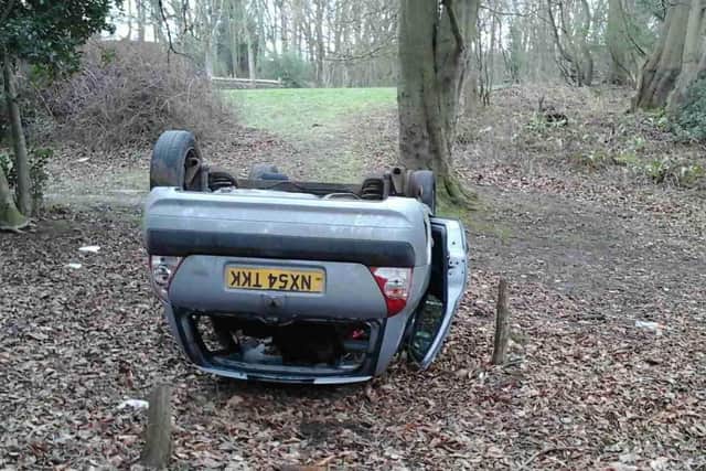The car was dumped on its roof near woods