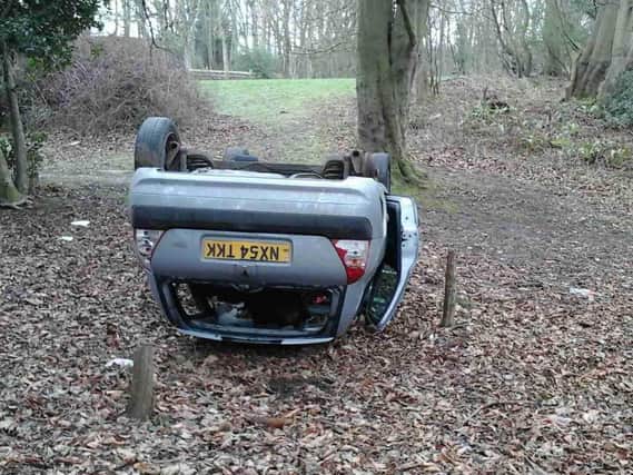 The car was dumped on its roof near woods