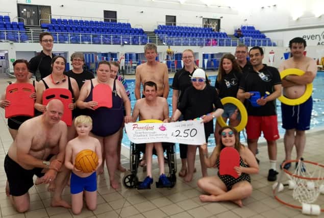 Valerie Aston, director at the Proudfoot, presents the cheque to the Scarborough Disabled Swimming Group.
