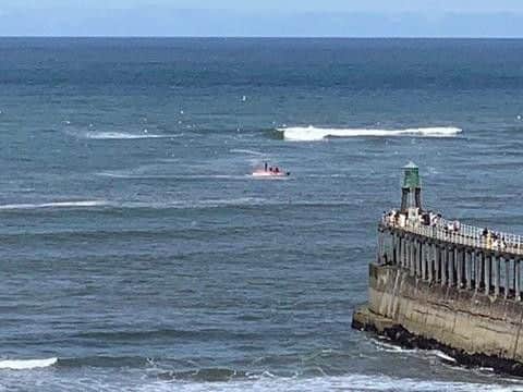 Four men were rescued off Whitby Harbour after their boat capsized.