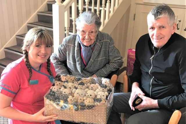 Magic Moments Club coordinator Skigh Beedham and residents Sheila Carlil and Dennis Muir with some of the knitted Bobby Buddies.