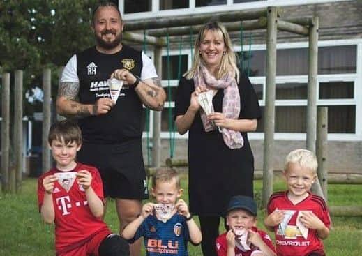Robbie Hawkes and Rosie Goodwin with some soccer school youngsters and their artwork. Photo by Jacob Lucas Film and Photography.