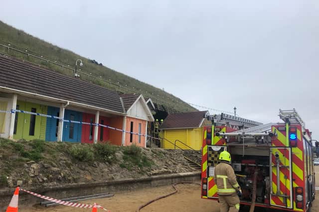 The blackened burnt out chalet can be seen to the rear.