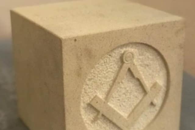 The ashlar block with the square and compasses logo.