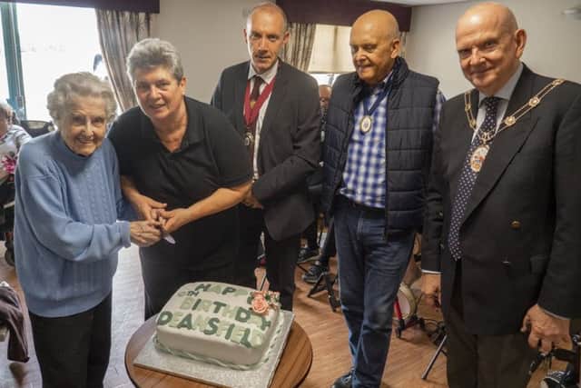 Deansfield Court resident Vera Fletcher, 97, cuts the cake at the 10th birthday party.