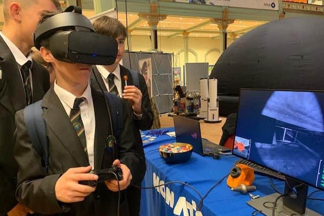 Students try virtual reality headsets from manufacturing firm Komatsu.