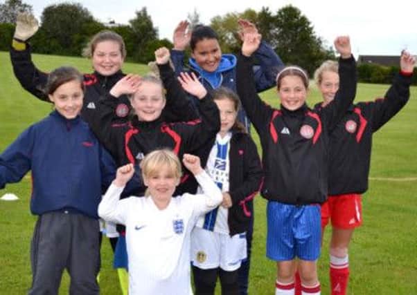 Chelsea Calvert, back centre, celebrates her sponsorship from Scarborough Ladies FC with some of the club's young stars