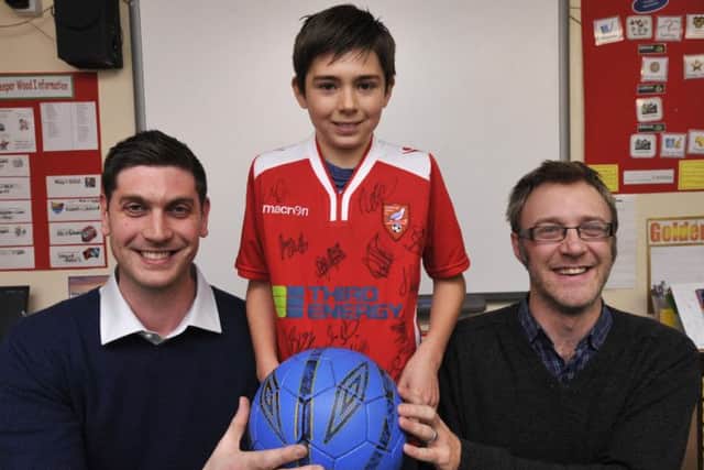 144831 West Heslerton School are presented with a signed Scarborough Atletic shirt to auction for the school From left Shaun Zablocki of sponsor Third Energy,Benjamin North and Nick Finch,commercial director at Scarborough Athletic. Picture by Neil Silk 28/11/14