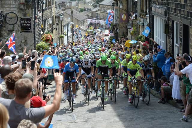 File photo dated 06-07-2014 of The peloton rides up Main Street as stage two of the Tour de France passes through Haworth. PRESS ASSOCIATION Photo. Issue date: Tuesday October16, 2014. The 101st Tour de France began in Leeds with a Grand Depart billed as the best ever. Expectations were matched as 4.8million people lined the road side from Leeds to Harrogate, York to Sheffield and then Cambridge to London. Yorkshire was bathed in sunshine as the peloton rode through Haworth. See PA story SPORT Christmas Gallery. Photo credit should read Martin Rickett/PA Wire.