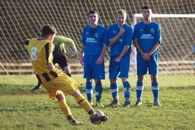 A Westover man aims a free kick over the Filey wall. Pictures: Steve Lilly