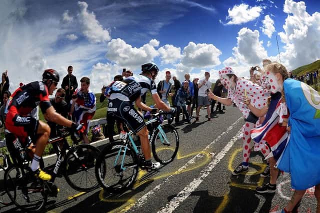 Fans cheer on cyclists as they tackle the Holme Moss climb during the Tour de France in Yoorkshire last summer. Picture by Simon Hulme