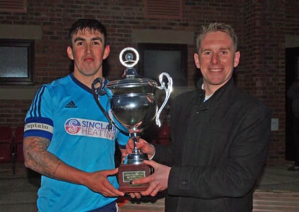 Newlands captain Matty Griffithsreceives the Kenward Cup from Sunday League's Geoff Osguthorpe