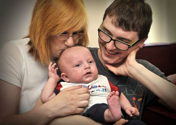 A tender moment. Baby Alfie McKenna Taylor with Mum Jananine Mackenna and Dad Robert Taylor look towards a brighter future with baby Alfie. pic Richard Ponter 152711c