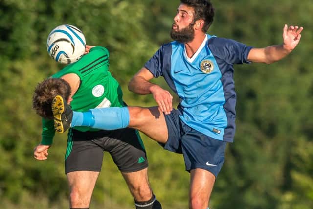 Whitby Fishermen's Sam Bailey battles for possession during his side's derby defeat to Sleights on Monday evening. Pictures by Brian Murfield