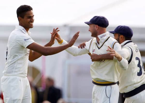 Moin Ashraf, left celebrating a wicket with Adam Lyth and Adil Rashid at North Marine Road, has been released by Yorkshire along with Daniel Hodgson and Jonny Tattersall