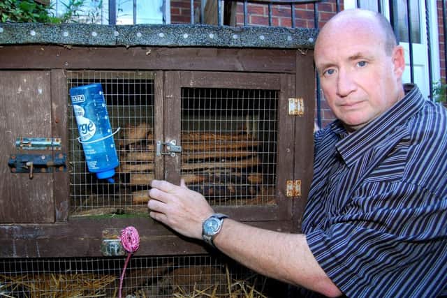Frank O'Neill with Nebula the Ferret's empty cage after she was attacked and killed.