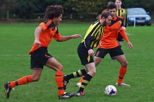 Scalby's Ben Webster carves his way past the Henderson brothers. 152126d Scalby v Edgehill Scarborough News Saturday League Division One 14-11-15@Carr Lane
