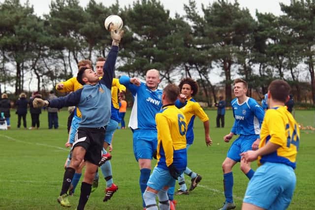 The Traf keeper punches clear under pressure from Heslerton's Josh Beach