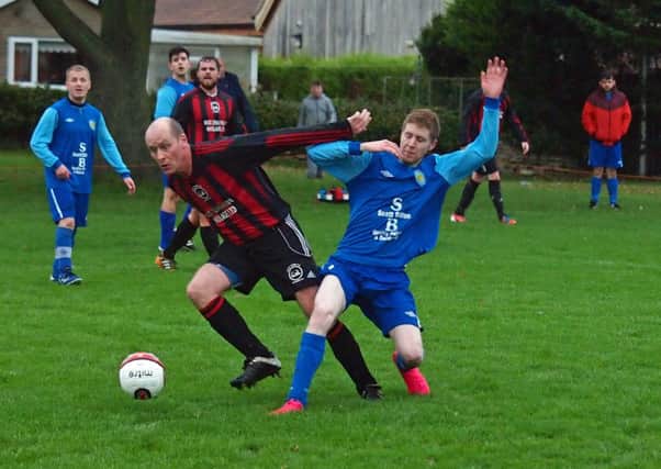 Ray Thorpe (West Pier Reserves, red and black kit) tangles with Ayton's Jamie Millar  152127c.Ayton v West Pier Res, Scarborough News Saturday League Division Two 14-11-15@Wilsons Lane.