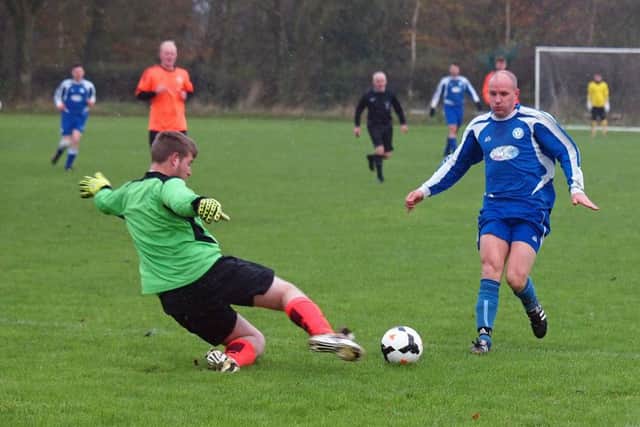 Snainton keeper and man of the match Hayden Backhouse slides in to deny Duchess' James Hughes, who scored a rare header in his side's 4-1 win. Picture: Steve Lilly