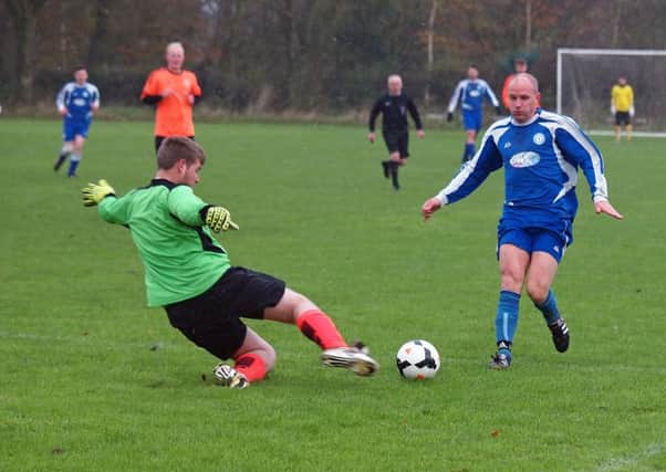 Snainton keeper and man of the match Hayden Backhouse slides in to deny Duchess' James Hughes, who scored a rare header in his side's 4-1 win. Picture: Steve Lilly