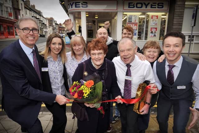 After fifty years service for Boyes Ian Livingstone cuts the tape for the Boyes grand sale...Ernie Gee of Boyes ,Eileen Livingstone, Ian,Chris Golder pictured with staff and Ian's family. pic Richard Ponter 160523