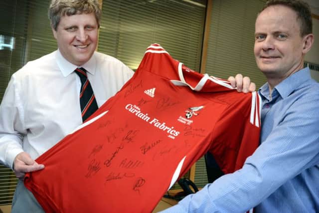 Yorkshire Coast Homes Chief Executive Shaun Tymon (right) and Scarborough Athletic FC Director Andy Troughton (left) mark a new chapter in the football club's history with the birth of Scarborough Athletic Frame Football Club. Shaun and Andy are holding a signed SAFC shirt, worn originall by Gary Hepples, which is one of many items being auctioned online to raise funds for the new club