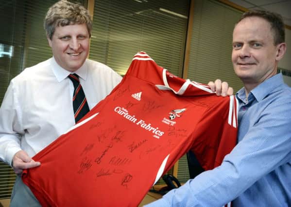 Yorkshire Coast Homes Chief Executive Shaun Tymon (right) and Scarborough Athletic FC Director Andy Troughton (left) mark a new chapter in the football club's history with the birth of Scarborough Athletic Frame Football Club. Shaun and Andy are holding a signed SAFC shirt, worn originall by Gary Hepples, which is one of many items being auctioned online to raise funds for the new club