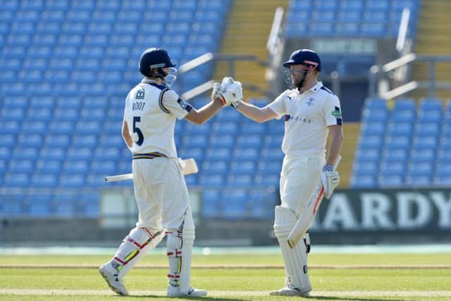 Joe Root and Jonny Bairstow celebrate their record- breaking partnership against Surrey.